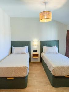 two beds sitting next to each other in a room at Casa 'El Tio Pedro' in Alcañiz