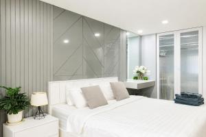 a white bedroom with a large white bed with white pillows at Sweet room in Nimnan in Chiang Mai