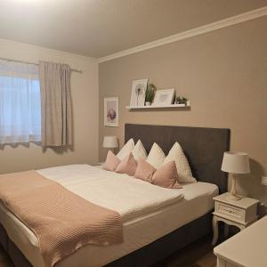 a bedroom with a large bed with pink pillows at Haus Adrian in Wald am Arlberg +79 photos