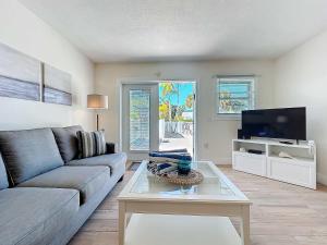 a living room with a couch and a tv at Blue Wave Villa East in Anna Maria