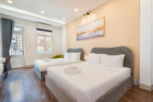 two beds in a hotel room with white sheets at Misa House - Starlit Saigon in Ho Chi Minh City +34 photos