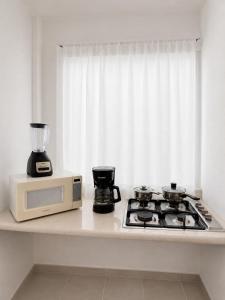 a kitchen counter with a microwave and a stove at Casa Balam Cayo Lobo in Cancún