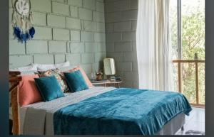 a bedroom with a bed with blue sheets and a window at CO Casa Ocean in Juan de Acosta