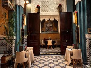 a restaurant with tables and chairs in a room at Dar Laabi - Riad Aya in Fez