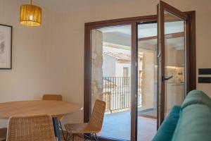 a dining room with a table and chairs and a balcony at Casa 'El Tio Pedro' in Alcañiz