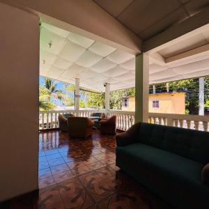 a living room with a couch and chairs on a porch at LA CASONA SV Hostal in La Libertad