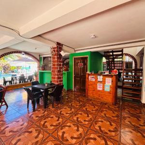 a dining room with a table and chairs in a room at LA CASONA SV Hostal in La Libertad