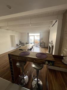 a kitchen and living room with a table and chairs at Saint Blaise in Les Herbiers
