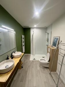 a bathroom with two sinks and a toilet and a shower at Saint Blaise in Les Herbiers