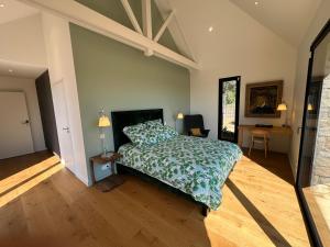 a bedroom with a bed with a green comforter at Er Rohellec in Baden