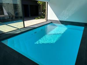 a swimming pool with blue water in a house at Er Rohellec in Baden