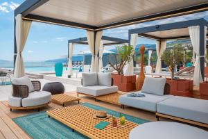 a living room with white furniture and a view of the ocean at Aminess Younique Vollo Hotel Residences in Opatija