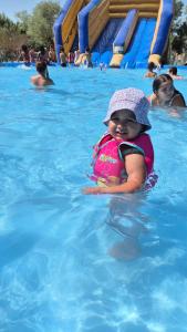 a baby wearing a life vest in a swimming pool at Joli rez de jardin in La Seyne-sur-Mer