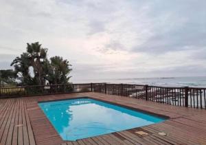 a swimming pool on a deck next to the ocean at Kei Sands Nr 6 in Kei-mouth Village +9 photos