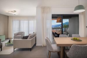 a living room and dining room with a table and chairs at Aminess Younique Vollo Hotel Residences in Opatija