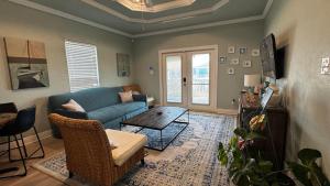 a living room with a blue couch and a table at 4BR Near the BeachFire PitFamily Friendly Stay in Bolivar Peninsula