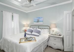 a white bedroom with a bed with a tray on it at 4BR Near the BeachFire PitFamily Friendly Stay in Bolivar Peninsula