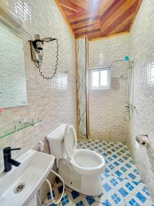 a bathroom with a white toilet and a sink at Bisso Hotel Bonaberi in Douala