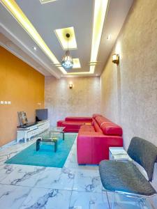 a living room with a red couch and a television at Bisso Hotel Bonaberi in Douala