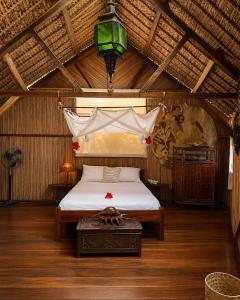 a bedroom with a bed in a room with a ceiling at Analatsara Eco Lodge in Ile aux Nattes
