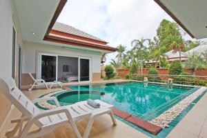 a swimming pool in the backyard of a house at Victoria Villa in Na Jomtien