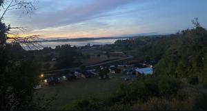 a group of tents in a field with a lake at Cabañas El Rincon del Sur in Colaco