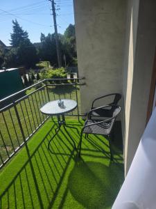 a table and two chairs on a balcony at Apartament Stokrotka in Olszyny