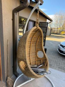 a wicker chair hanging from a building at Highveld Nook in Sasolburg