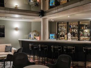 a bar with stools and a counter in a room at Mercure Hotel Pforzheim in Pforzheim