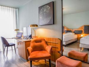 a bedroom with a desk and a chair and a bed at Mercure Hotel Pforzheim in Pforzheim +179 photos