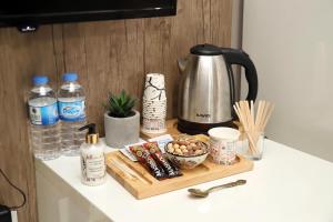 a counter top with a coffee pot and cups and bottles of water at Alkış Otel in Iğdır