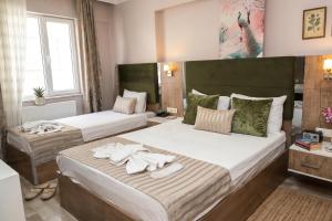 two beds in a hotel room with towels on them at Alkış Otel in Iğdır