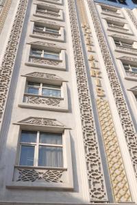 a tall white building with many windows on it at Alkış Otel in Iğdır