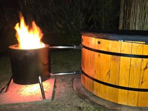 a pot of fire next to a wooden barrel at Moss & Moon Cabins in Stormsrivier