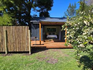 a tiny house on a deck with a fence at Moss & Moon Cabins in Stormsrivier