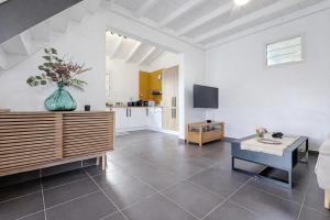 a living room with a table and a vase of flowers at Private Villa, Castel in Lamentin