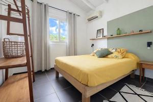 a bedroom with a bed with yellow sheets and a ladder at Private Villa, Castel in Lamentin +12 photos