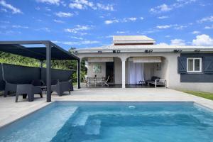 a swimming pool in front of a house at Private Villa, Castel in Lamentin