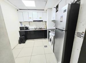 a small kitchen with a refrigerator and a sink at Dream International City Homes in Dubai