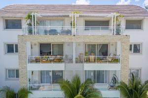 a large white building with balconies and palm trees at Elegant 2 Bedroom Apartment with Pool in La Laguna