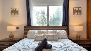 a bedroom with a white bed with two lamps and a window at Elegant 2 Bedroom Apartment with Pool in La Laguna +71 photos