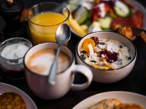 a table with two cups of coffee and a plate of food at You Hotel Budapest - Handwritten Collection in Budapest