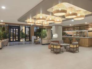 a lobby with tables and chairs and chandeliers at Mercure Antalya Konyaalti in Antalya +94 photos