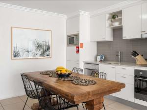 a kitchen with a wooden table with a bowl of fruit on it at The Sebel Byron Bay in Byron Bay +118 photos