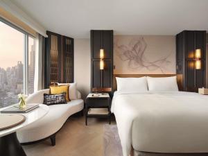 a hotel room with a large bed and a couch at Fairmont Bangkok Sukhumvit in Bangkok