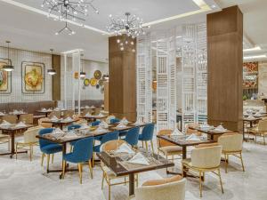 a restaurant with wooden tables and blue chairs at Mercure Mactan Cebu in Mactan