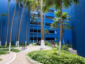 a blue building with palm trees in front of it at Club Regina Cancun in Cancún