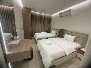 a hotel room with two beds and a table at The Pearl Inn in Nizwa