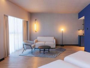 a living room with a couch and a table at Novotel Madinah in Medina