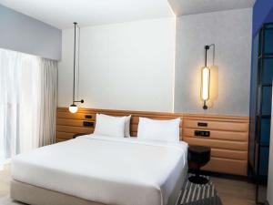 a bedroom with a large white bed and a window at Novotel Madinah in Medina +40 photos